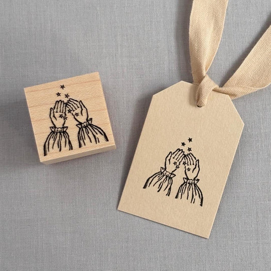 Stamp of hands collecting star sand